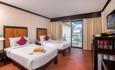 a hotel room with two beds and a balcony at The Front Village - SHA Plus in Karon Beach