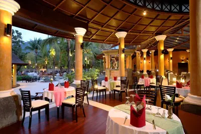 a restaurant with white tables and chairs with red napkins at The Village Resort - SHA Plus in Karon Beach