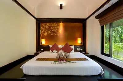 a bedroom with a large white bed with a wall at The Village Resort - SHA Plus in Karon Beach