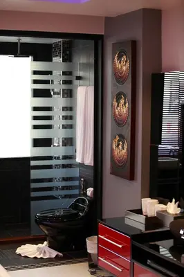 a bathroom with a black toilet and a mirror at Absolute Bangla Suites in Patong Beach