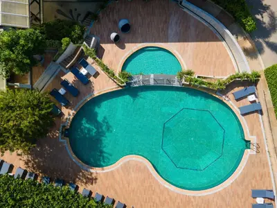 an overhead view of a swimming pool with chairs and trees at Krabi Tipa Resort in Ao Nang Beach