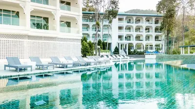 a swimming pool with lounge chairs next to a building at Krabi Tipa Resort in Ao Nang Beach