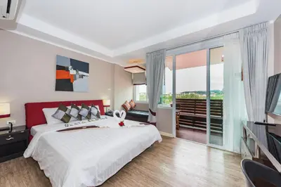 a bedroom with a large bed and a large window at Kata Beach Studio Phuket in Kata Beach