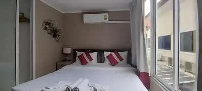 a bed in a small room with a window at Kata Beach Studio Phuket in Kata Beach