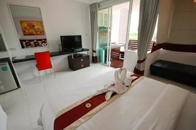 a hotel room with a bed and a television at Kata Beach Studio Phuket in Kata Beach