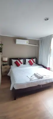 a bedroom with a large white bed with red pillows at Kata Beach Studio Phuket in Kata Beach