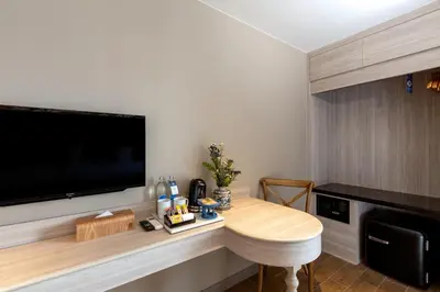 a room with a table and a flat screen tv at Sawaddi Patong Resort & Spa by Tolani in Patong Beach