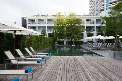 a pool with chairs and umbrellas in a building at Nap Patong in Patong Beach