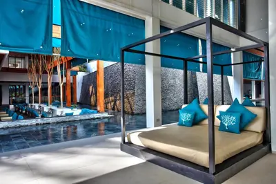a bed in the middle of a room with a pool at Nap Patong in Patong Beach