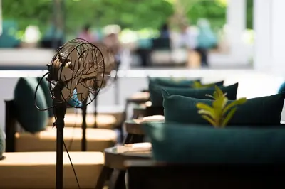 a fan sitting on top of a table with chairs at Nap Patong in Patong Beach