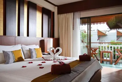 a bedroom with a bed with flowers on it at Baan Karonburi Resort in Karon Beach