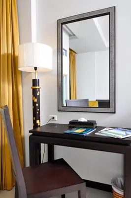 a desk with a mirror and a lamp and a chair at Baan Karonburi Resort in Karon Beach
