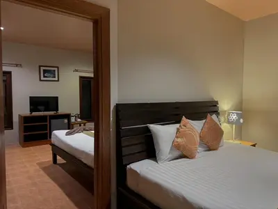 a bedroom with two beds and a mirror at Sunda Resort in Ao Nang Beach