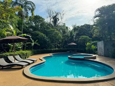 a swimming pool with chairs and an umbrella at Sunda Resort in Ao Nang Beach
