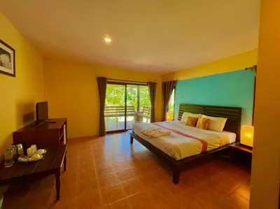 a bedroom with a bed and a desk and a television at Sunda Resort in Ao Nang Beach