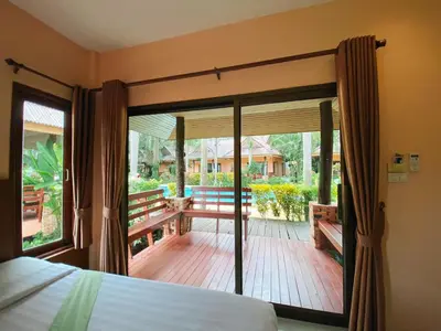 a bedroom with a bed and a large sliding glass door at Sunda Resort in Ao Nang Beach