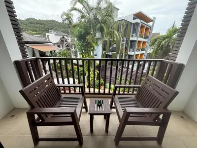 a balcony with two chairs and a table on a balcony at Apasari Krabi - SHA Extra Plus in Ao Nang Beach