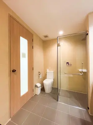a bathroom with a toilet and a glass shower at Apasari Krabi - SHA Extra Plus in Ao Nang Beach