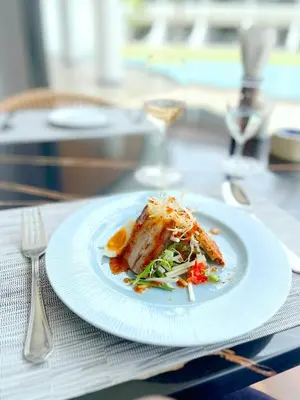a white plate with food on a table at Amora Beach Resort Phuket in Bang Tao Beach