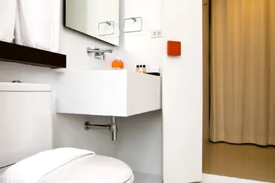 a bathroom with a white toilet and a sink at The Album Hotel in Patong Beach