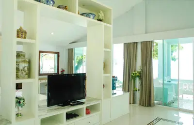 a white living room with a flat screen tv at Racha Island Resort (Rayaburi) in Ko Racha Yai