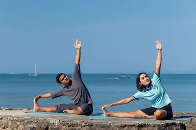 a man and a woman doing yoga on the beach at Krabi Resort in Ao Nang Beach