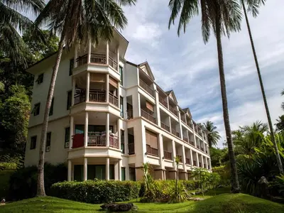 a white building with palm trees in front of it at Krabi Resort in Ao Nang Beach