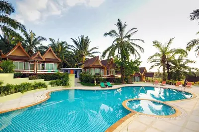 a resort swimming pool with villas in the background at Palm Paradise, Aonang Resort in Ao Nang Beach