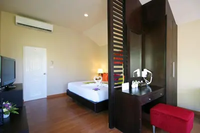 a bedroom with a bed and a desk and a mirror at Palm Paradise, Aonang Resort in Ao Nang Beach