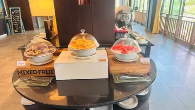 a table with bowls of fruit on top of it at Anyavee Tubkaek Beach Resort in Tab Kaek Beach