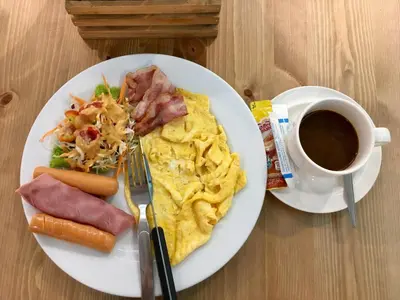 a plate of breakfast food with a cup of coffee at Q Victory Patong Hotel in Patong Beach