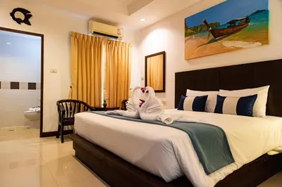 a bedroom with a bed with two stuffed animals on it at Q Victory Patong Hotel in Patong Beach