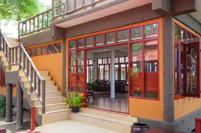 a house with an orange door and stairs at PP Erawan Palms Resort in Phi Phi Don