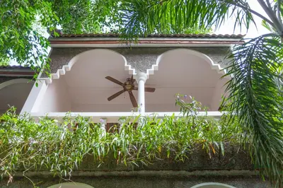 a clock on the side of a building with plants at Tropica Bungalow Beach Hotel in Patong Beach
