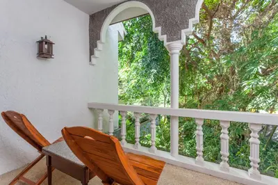 a balcony with two chairs and a window at Tropica Bungalow Beach Hotel in Patong Beach