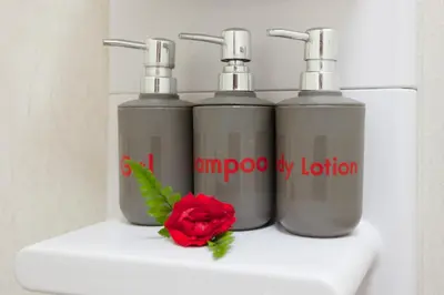 three bottles of soap and a red rose on a sink at Tropica Bungalow Beach Hotel in Patong Beach