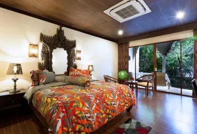 a bedroom with a bed with a colorful bedspread at Tropica Bungalow Beach Hotel in Patong Beach