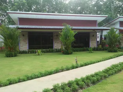a house with a lawn in front of it at Phuket Sirinapha Resort in Nai Yang Beach