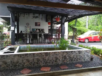 a patio with a stone wall and a bar at Phuket Sirinapha Resort in Nai Yang Beach