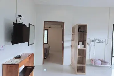 a living room with a television and a book shelf at Nongthale Mountain View in Klong Muang Beach