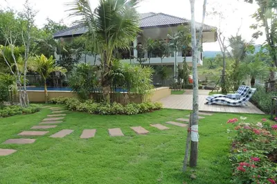 a house with a palm tree and a yard at Nongthale Mountain View in Klong Muang Beach
