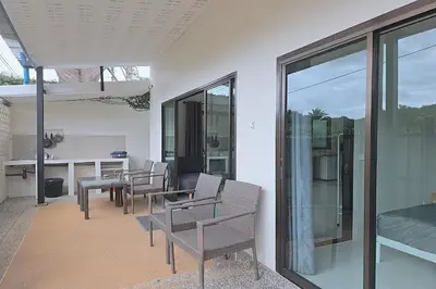 a patio with chairs and a table and glass doors at Nongthale Mountain View in Klong Muang Beach