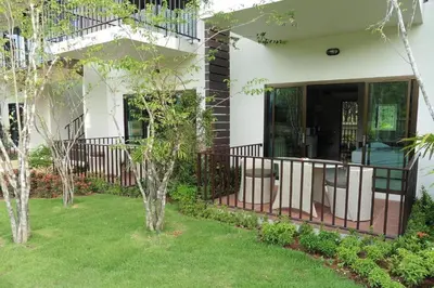 a white house with a balcony and some trees at Nongthale Mountain View in Klong Muang Beach
