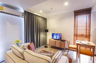 a living room with a couch and a table and a television at The Deck Condominium by Lofty in Patong Beach