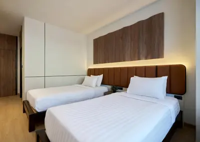 two beds in a hotel room with white sheets at Panmanee Hotel-Newly Renovated in Phi Phi Don