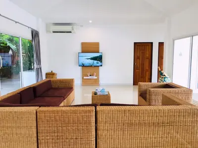 a living room with a couch and chairs and a tv at Baan Anna in Ao Nang Beach