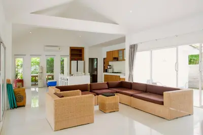 a living room with a brown couch and wicker chairs at Baan Anna in Ao Nang Beach