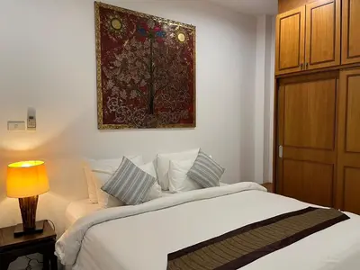 a bedroom with a bed and a painting on the wall at Baan Lalle in Ao Nang Beach