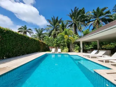 a swimming pool with lounge chairs and a villa at Baan Lalle in Ao Nang Beach