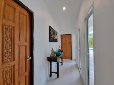 a hallway with a door and a table next to a room at Baan Lalle in Ao Nang Beach